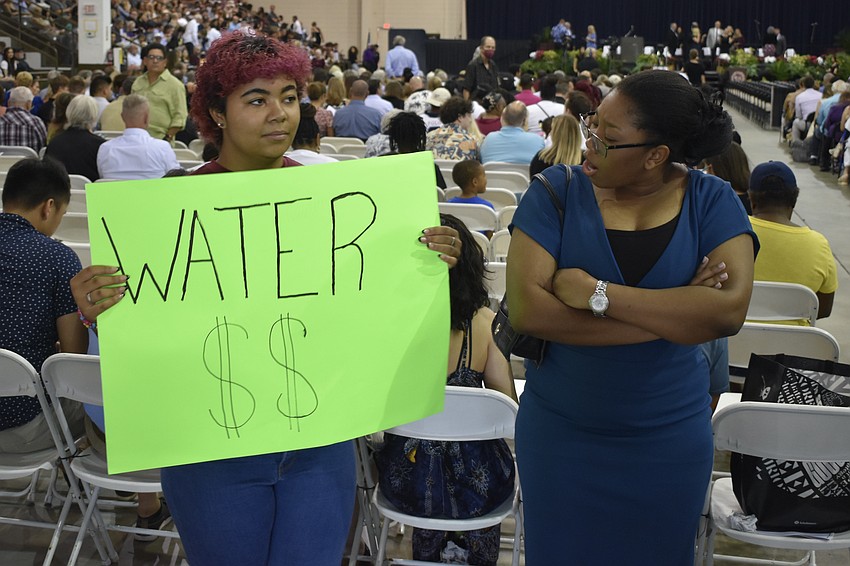 Amaris Gonzalez and Sadorah Lormil of JROTC direct attendees to where they can buy water.
