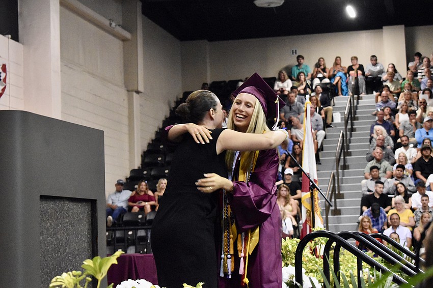 Principal Erin Haughey presents graduate Ella Williams with the Edward Brown leadership award.
