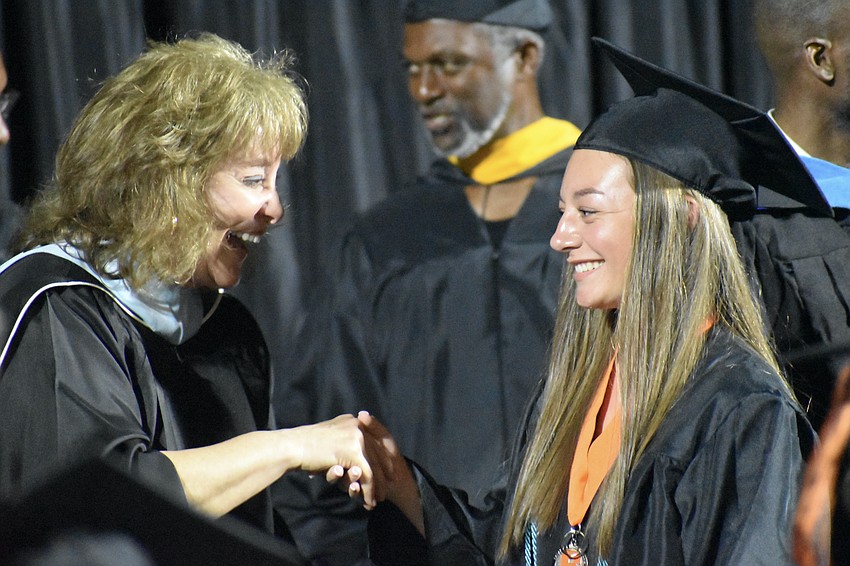 School board member Robyn Marinelli shakes hands with Avalon Selby.