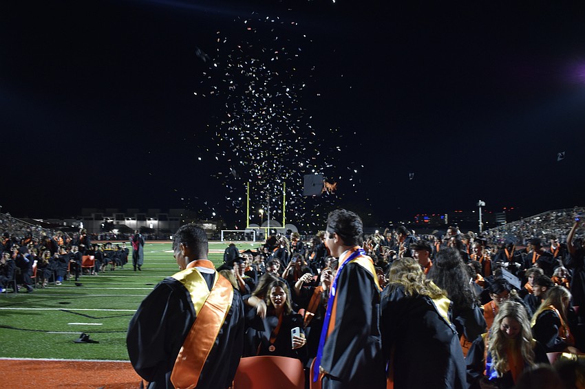 A flurry of confetti appears as students graduate.