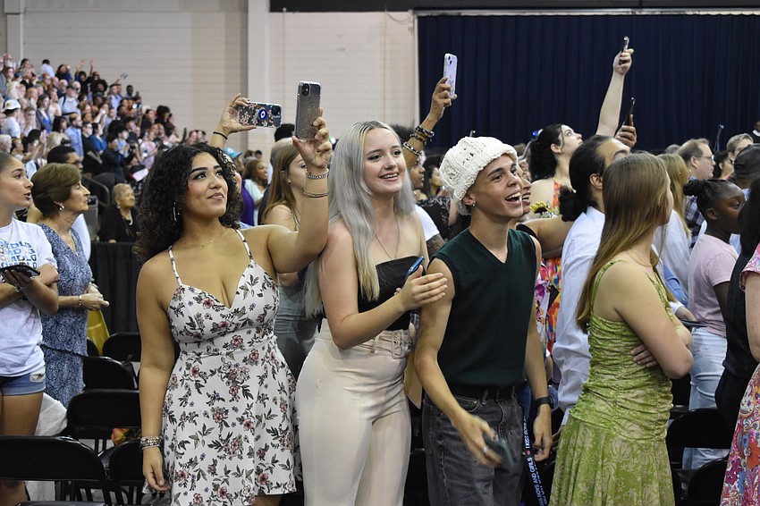 Luna Bermudez, Lilia Pearson, and Christain Hall watch the procession of students.