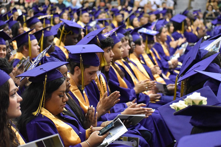 Graduates applaud during the ceremony.