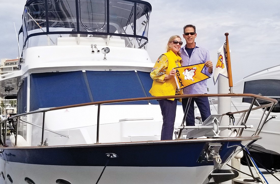 Joni and Ziggy von Schweinitz show off the gold flag they received from the America’s Great Loop Cruisers’ Association for completing the Great Loop.