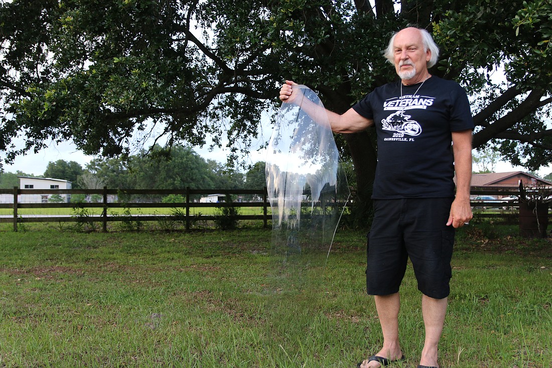 Bob Blankenship holds up a piece of windshield that fell on his property on May 17. Photo by Jarleene Almenas
