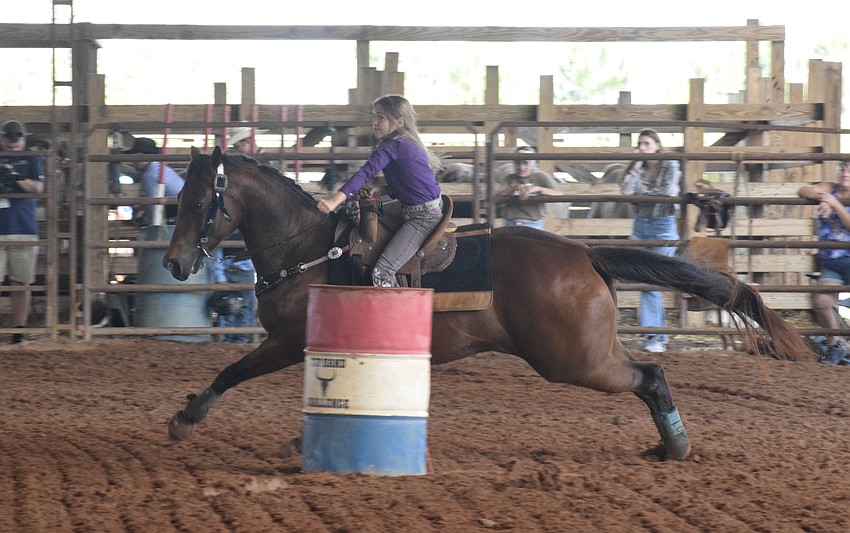 Myakka City Elementary School's Chaislee Manful and her horse sprint around the barrels in the arena.