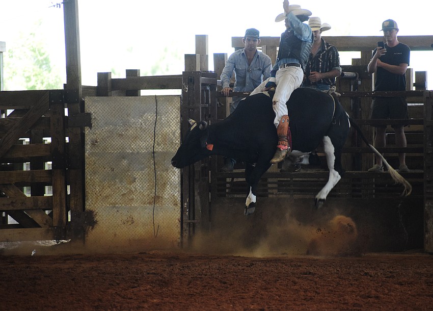Elijah Gore holds on as a bull tries to buck him off.