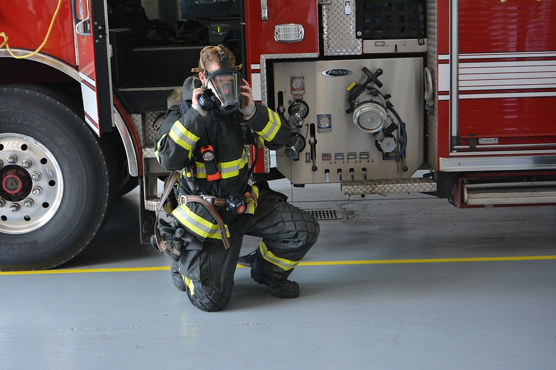 Firefighter/paramedic Trey Bowlin shows what protective gear is worn when responding to a fire.