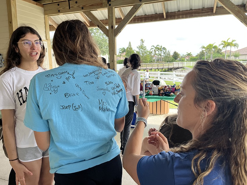 Lakewood Ranch Preparatory Academy freshman Olivia Autrey stands still so physical education teacher Maggie Sharrer can sign her shirt.