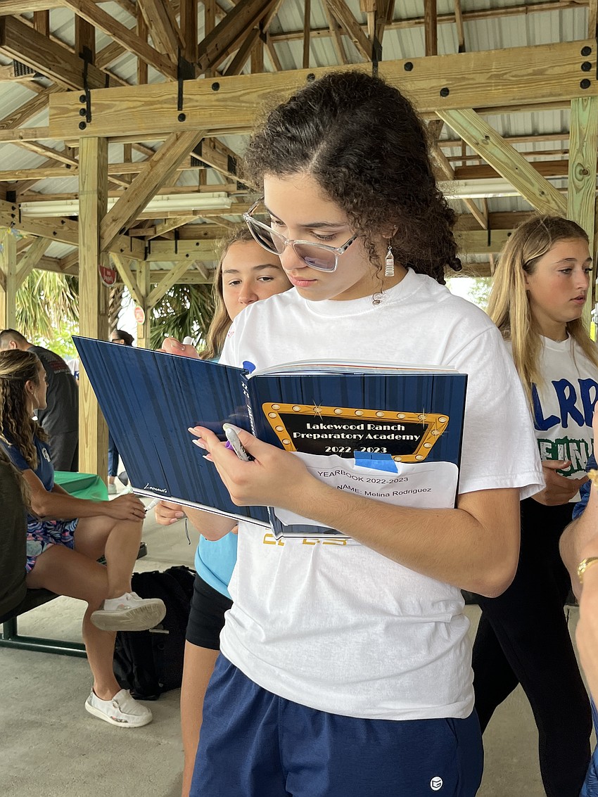 Lakewood Ranch Preparatory Academy freshman Leah Serrapica signs a yearbook. She says her freshman year at the new school has been a rollercoaster.