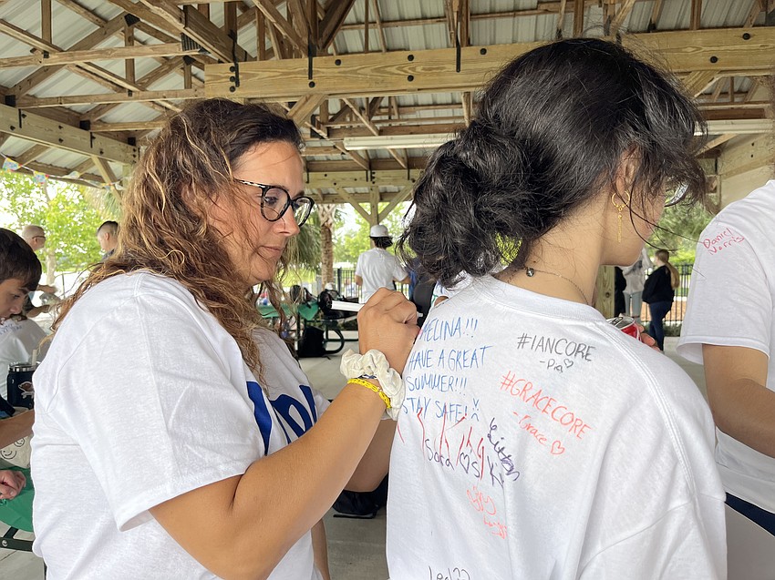 Lakewood Ranch Preparatory Academy's Nicole Durbal signs freshman Sara Johnson's T-shirt.