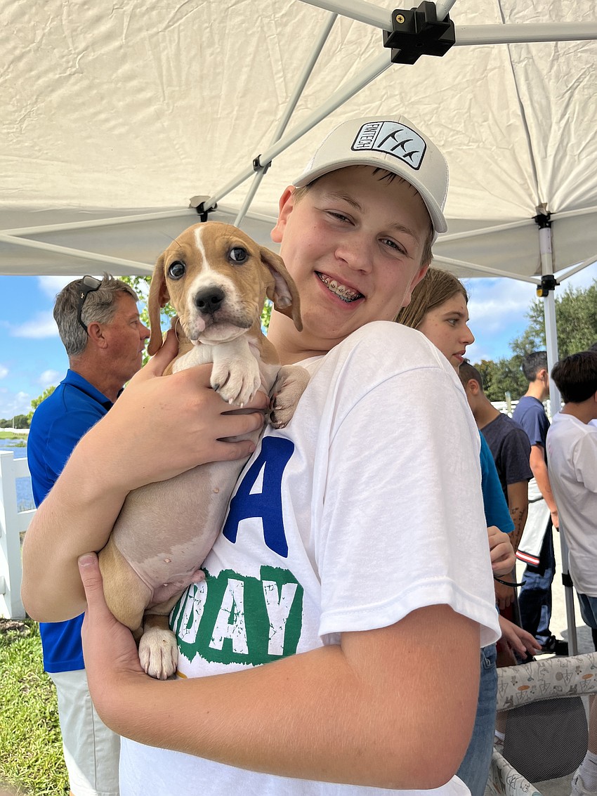 Lakewood Ranch Preparatory Academy freshman Daniel Norris loves petting a Nate's Honor Animal Rescue puppy.