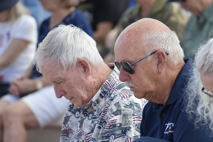 Bernie Regan and Mike MacDonald bow their heads in prayer.