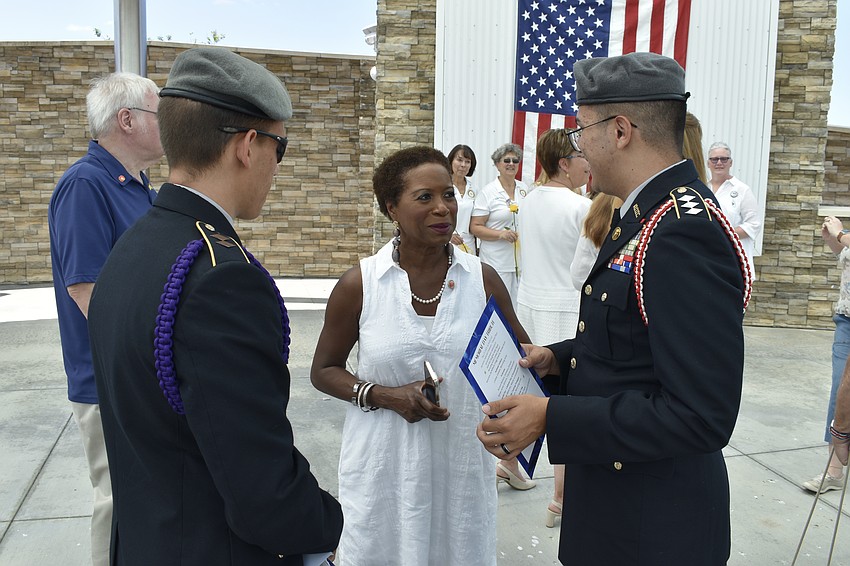 Sarasota Military Academy cadet Raphael Fabyanic, Tribute Chair Renée James Gilmore, and Sarasota Military Academy cadet Akiel Reyes Melendez talk with one another.