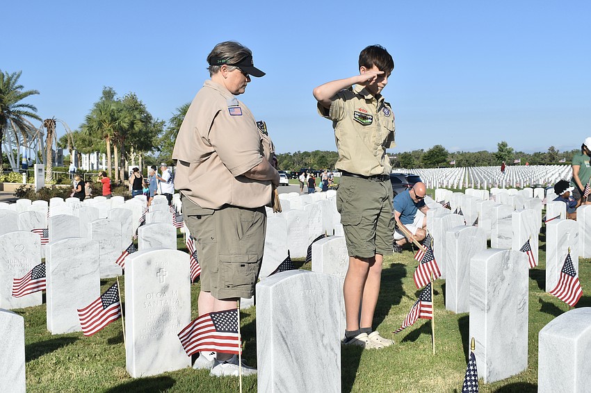 Danelle and Braylon McCracken take a moment to honor each service member as they place flags at the graves.