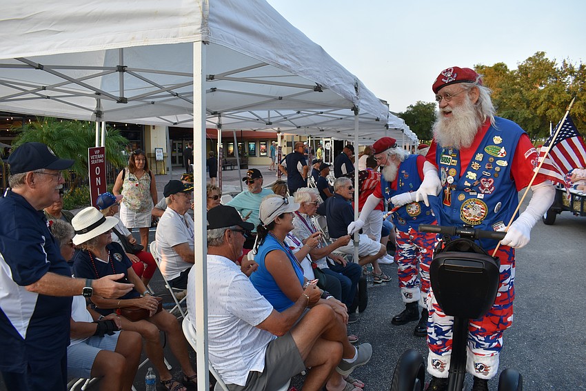 Santa Steve, AKA Steven Hadala, chats with veterans during the Tribute to Heroes Parade. Hadala represents the West Central Honor Flight Honor Guard, professional Santas who honor veterans.