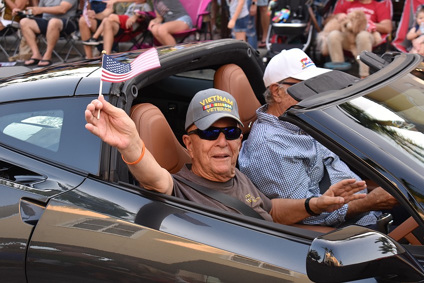U.S. Army veteran Ned Fishman of Eagle Trace waves to the crowd during the Tribute to Heroes Parade.