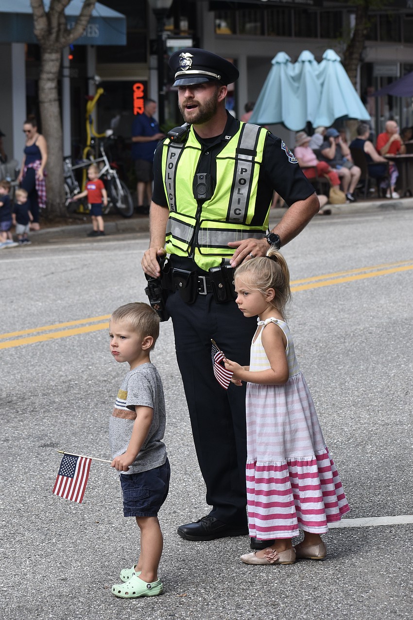 2-year-old Jackson Pietron, his father Officer Michael Pietron, and his 5-year-old sister Ellie Pietron await the arrival of the parade.