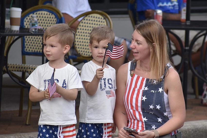 3-year-old Oliver and Noah Sebastianelli and their mother Allie Sebastianelli welcome the parade vehicles.