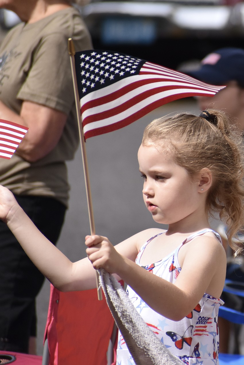 6-year-old Lilyana Tidwell waves a pair of flags.