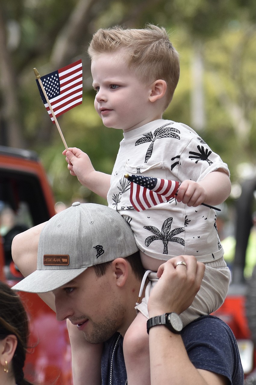 Brett Waton and 2-year-old Roman Watson watch the parade.