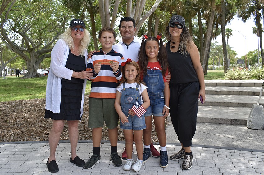 Jan Hamel Solomon to 11-year-old Martin Alvarez who stands alongside Fernando Alvarez, 6-year-old Bianca Alvarez, 9-year-old Maria Victoria Alvarez, and Astrid Lambis. The key was given to her father, Chaplain J.D. Hamel, when J.D. Hamel Park, where the ceremony took place, was dedicated in his name.