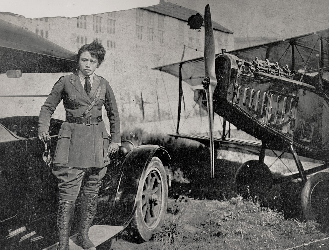 Aviator Bessie Coleman stands on the running board of a Ford Model T automobile next to her Curtiss JN-4 Jenny airplane. Coleman is the first Black Native American woman to earn a pilot’s license.