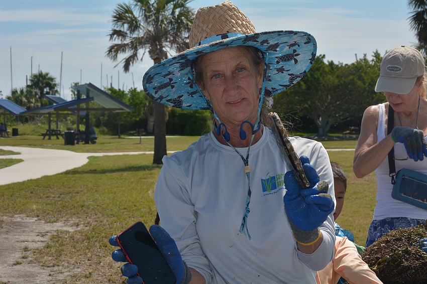 Ronda Ryan holds two phones found at the bottom of the bay.