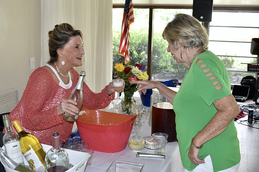 Ann Durloo offers a drink to Pat Rowe.