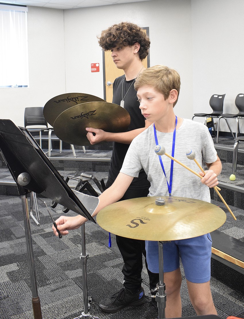 Milan Ruggiero, a rising freshman at Parrish Community High School, plays crash symbols while Landon Merrill, a rising eighth grader at Carlos E. Haile Middle School, plays triangle during a percussion sectional.