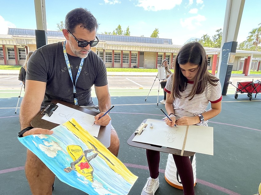 Joe Gibson, an art teacher at Carlos E. Haile Middle School, takes Haven Wood, a rising seventh grader at Haile, through how to draw a person.
