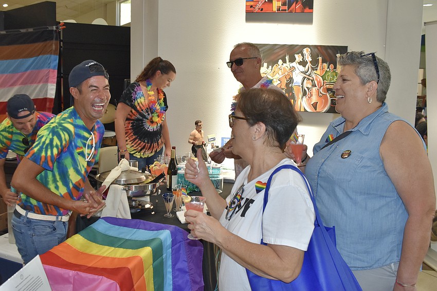 Joel Cali of Inspired Living talks with Audrey Souza and Carla Resvanis as they accept some drinks.
