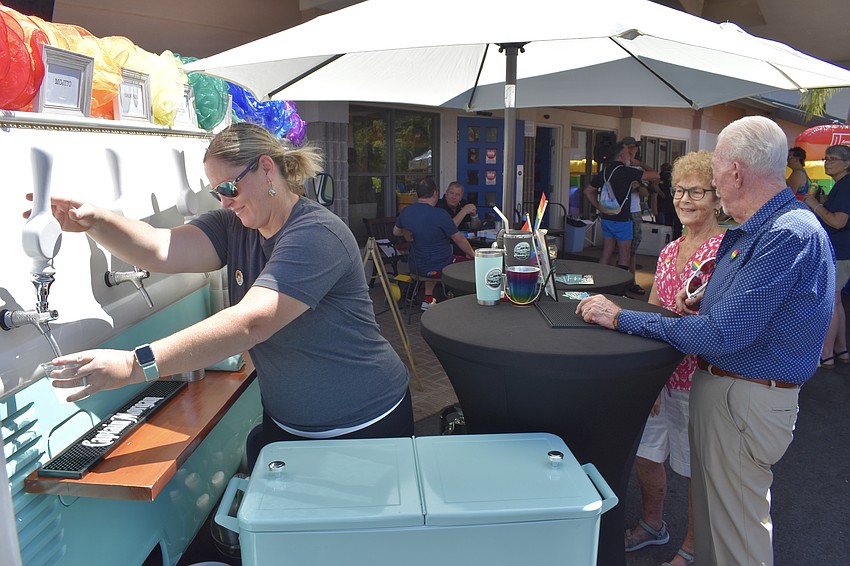 Stephanie Folckemer of Kombi Keg Mobile Bar pours drinks for Kathy Hinote and Roscoe Ruyle.