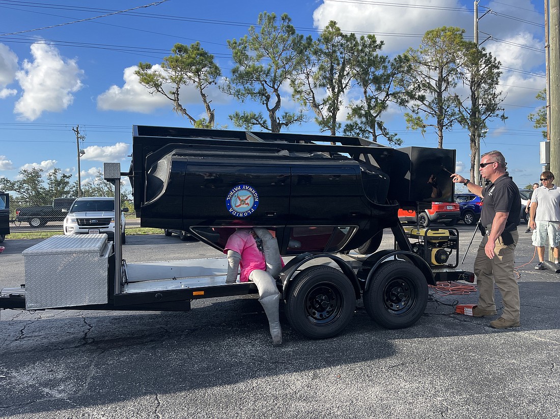 Sgt. Steve Gaskins, the public affairs officer for the Florida Highway Patrol, uses a vehicle rollover simulator to demonstrate the dangers of driving aggressively during an FDOT seminar.