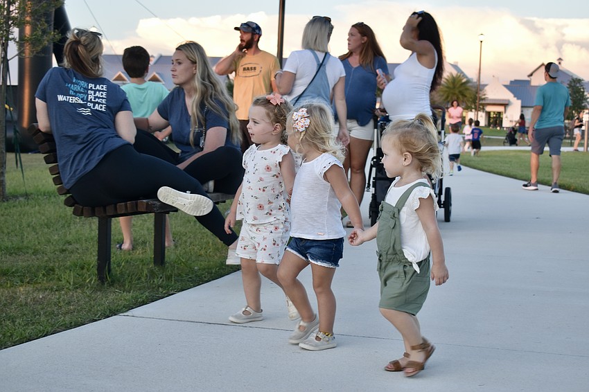 Stella Marek, Mason Miller and Stevie Martinez use the buddy system to walk around the park.