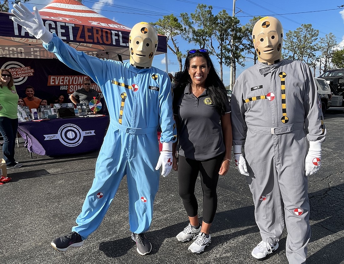 Janice Martinez, a law enforcement liaison for the Florida Department of Transportation, joins with a couple of crash dummies to encourage people to drive safely.