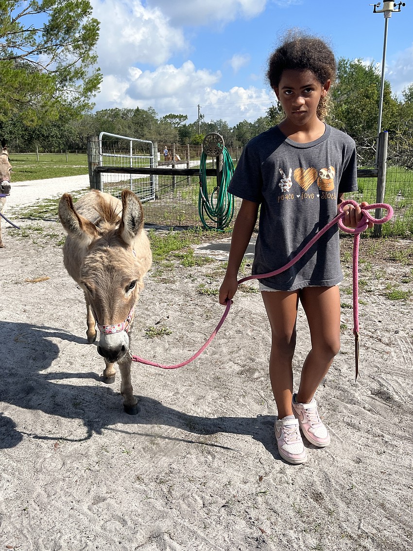 Soleil Williams, who is 9, walks Bruiser. 