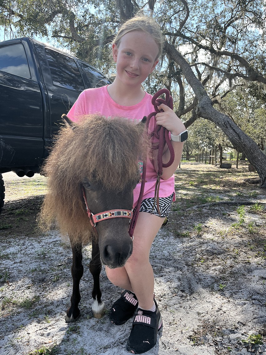 Penny Wells, who is 9, hugs Sailor. 