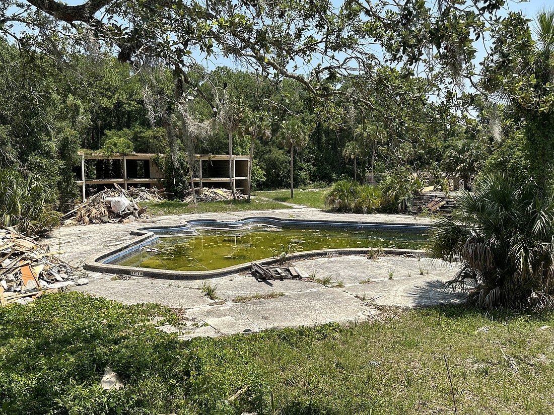 The pool at the former Thunderbird Motor Hotel at 5865 Arlington Expressway in Arlington is filled with rainwater and algae June 6. The hotel, which opened around 1959, was sold several times and then condemned by the city.