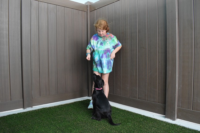 Kinsley Chadwich, who is 8, gets Lux to sit with the help of a treat.