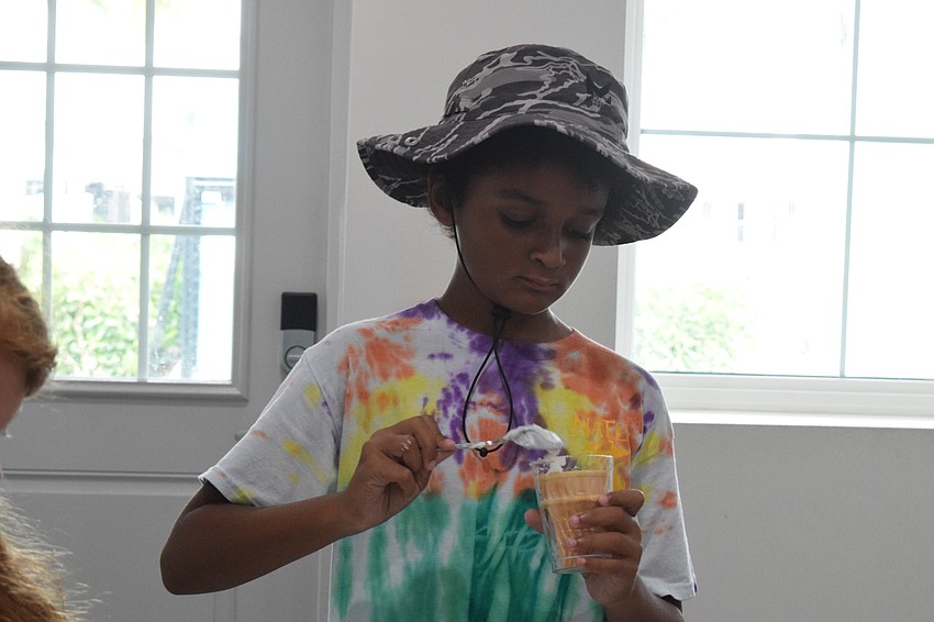 Paxton Davis, who is 10, takes his time making a doggie sundae.