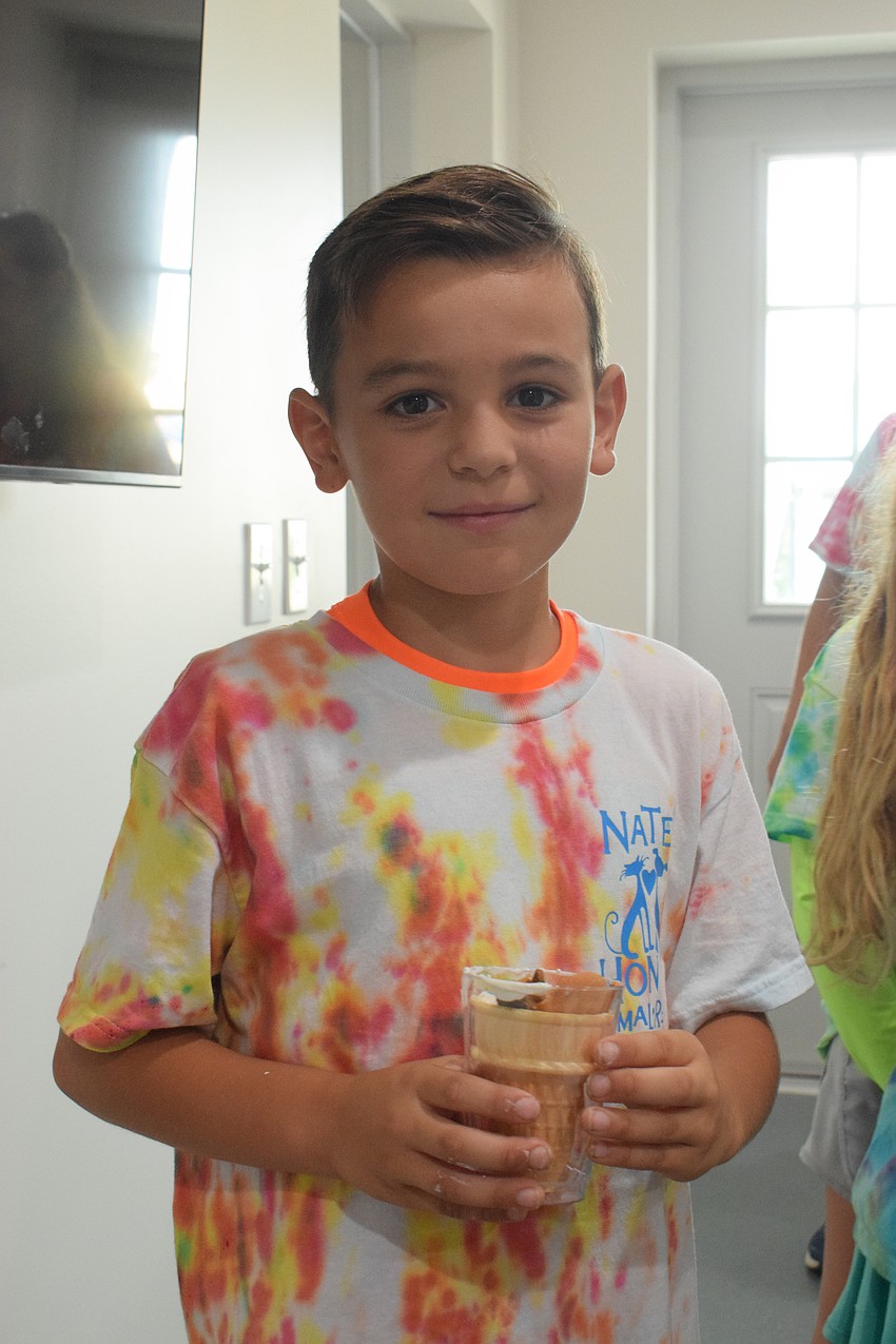 James Kombogiannis, who is 8, makes a sundae for one of the dogs at Nate's Honor Animal Rescue. 