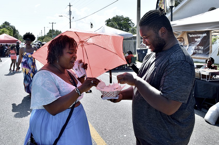 Gemini Fox accepts fried doughnuts from Ken Jackson.