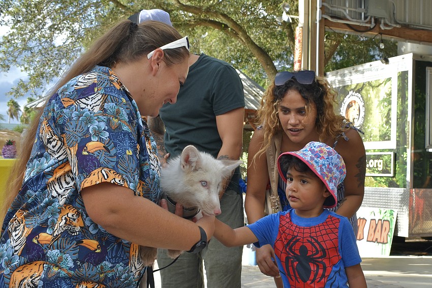 Sasha Kenyon gives Ellen Matos and 4-year-old Mason Romero a turn with Sparky, a North American red fox.