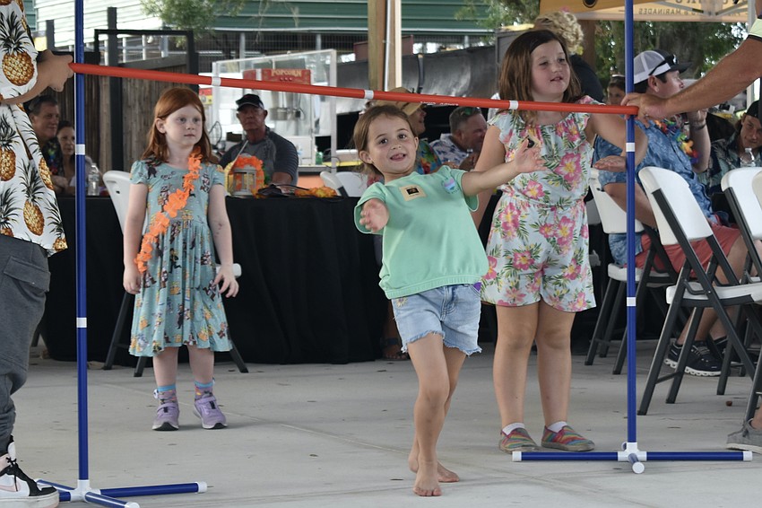5-year-old Bennett Maryott, 7-year-old Charlie Carmona, and 7-year-old Delilah Vaccaro play limbo.