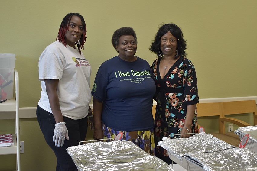Danette Williams, Valerie Buschand, and Valerie Butler offer barbeque at the Betty J. Johnson North Sarasota Public Library.