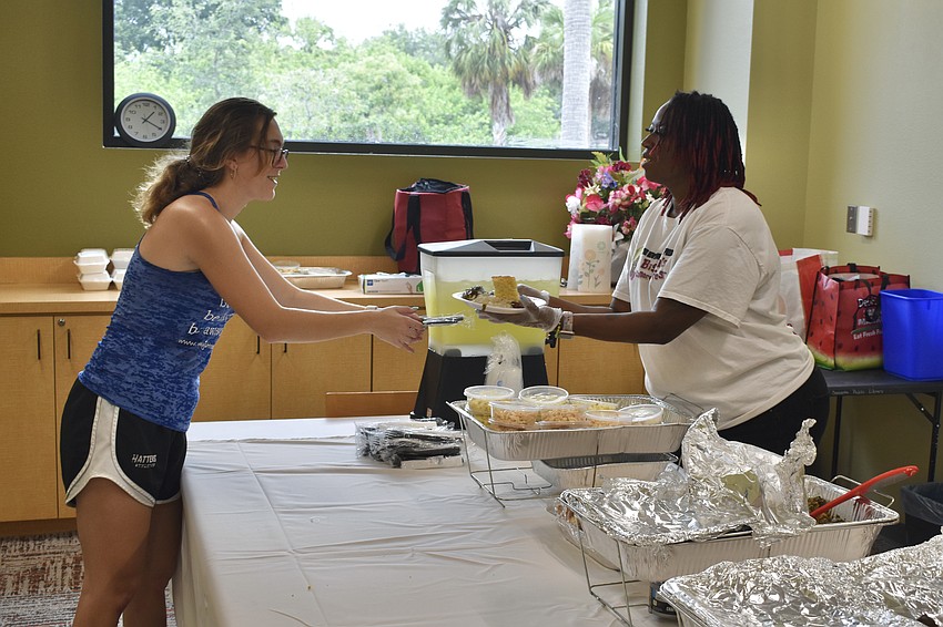Cas Bradley accepts a meal from Danette Williams at the Betty J. Johnson North Sarasota Public Library on June 16.