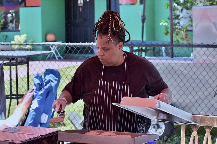 Tina Caldwell flips hamburgers at the of Butta Clucka's stand.