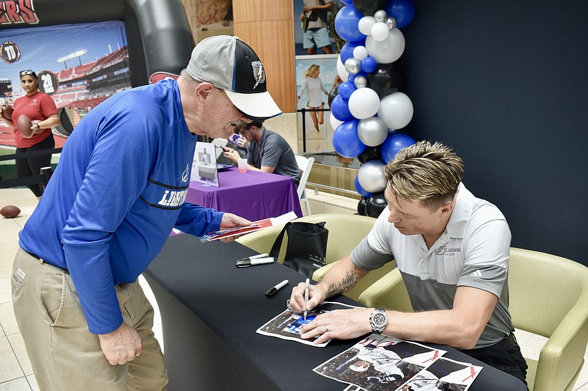 Venice resident Robert Hunek wears a Tampa Bay Lightning shirt to the Meet & Greet with two-time Stanley Cup champion Ruslan Fedotenko and asks him to sign his photo 