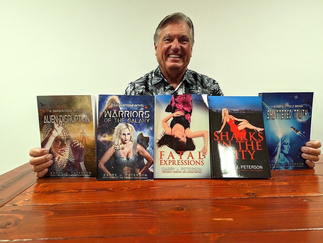 Garry Peterson displays his five fiction books. The fourth book in his science fiction series is due out next month. Photo by Brent Woronoff