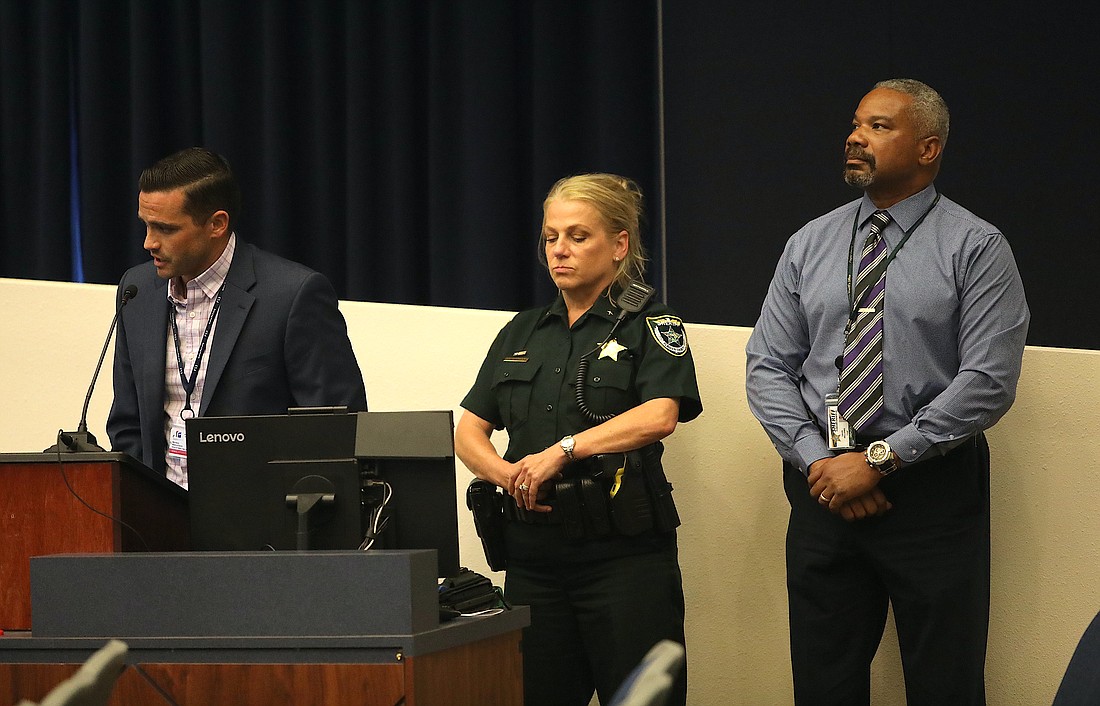 Flagler Schools Safety Specialist Tom Wooleyhan, with Flagler County Sheriff Commander Jennifer Nawrocki and FCSO Chief David Williams, reads a resolution to adopt a guardian program. The resolution failed, 3-2. Photo by Brent Woronoff